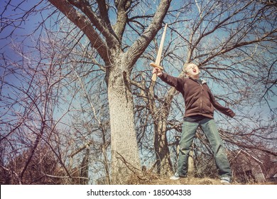 Boy playing with a sword outdoors