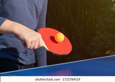 A Boy Playing Table Tennis, Ping Pong Outside In The Garden.