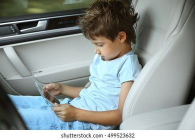 Boy Playing With Tablet In Car