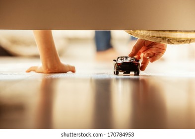 Boy Playing With Toy Car Overhang From The Bed