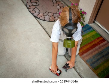 Boy Playing With Toys While Wearing Gas Mask At An Apartment Complex. Image Can Be Used For Coronavirus,Covid-19,Pandemic,air Pollution, Second Hand Smoke ,or Asthma