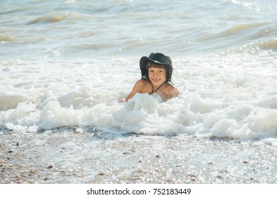 A boy is playing in the waves on the beach