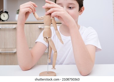 A boy playing wooden mannequin, articulated doll at home, kid, child trying different poses and roles of people - Powered by Shutterstock