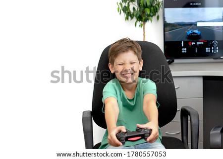 Boy plays a computer game with headphones and a joystick, game console.