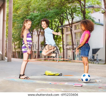 Boy plays elastics with friends outside