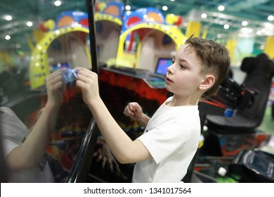 Boy Plays Game On Large Touch Screen In Amusement Park