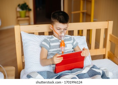 A boy plays on a tablet during a lung inhalation procedure. Medicine and care - Powered by Shutterstock