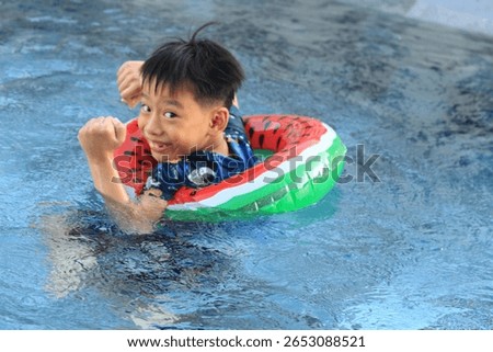 Boy Plays in a pool with a floatation device. 
