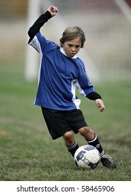 Boy Plays Soccer In A A Blue Shirt