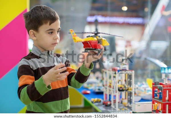 a boy\
plays with a toy helicopter in\
kindergarten
