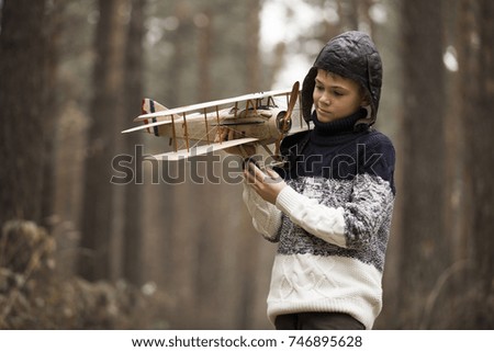 a boy plays in the woods with a toy plane. autumn games in the woods.the plane