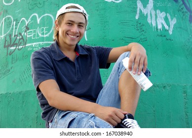 Boy posing in front of graffiti wall