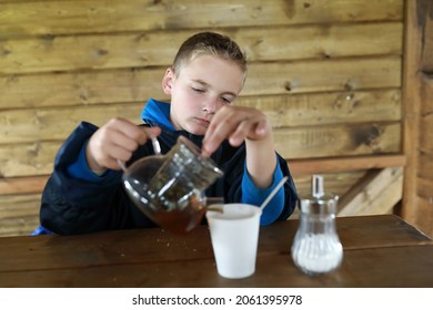 Boy Pouring Herbal Tea On Restaurant Terrace