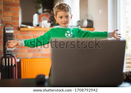 The boy practices at home in front of the computer as part of an online physical education lesson due to closed schools becouse of pandemic Coronavirus Covid-19
