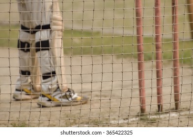 Boy is practicing cricket batting in net. - Powered by Shutterstock