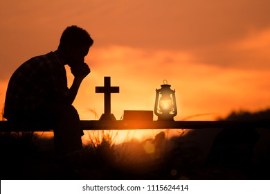 boy praying and reading holy bible on wood , christian silhouette concept.