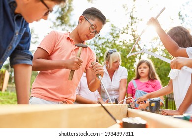 Boy Prying Wood With A Chisel Or Chisel In The Holiday Camp Workshop