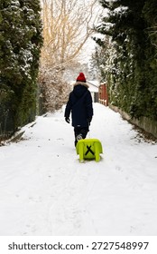Boy Pulling a Sled Through Snow