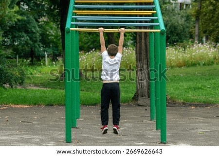 The boy pull-ups on the horizontal bar