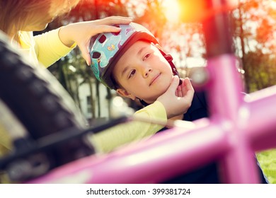 Boy Putting On A Bike Helmet