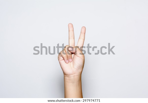 Boy raising two fingers up on hand it is\
shows peace strength fight or victory symbol and letter V in sign\
language on white\
background.\
