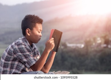 Boy Reading And Studying The Bible.