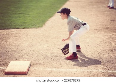 Boy ready at first base. Shallow focus