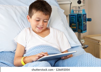 Boy Relaxing In Hospital Bed With Digital Tablet