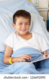 Boy Relaxing In Hospital Bed With Digital Tablet