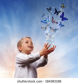 Boy releasing butterflies into the air concept for freedom, peace and spirituality