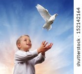 Boy releasing a white dove into the air concept for freedom, peace and spirituality