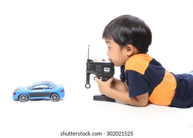 Boy With Remote Control Makes Toy Car Isolated On White