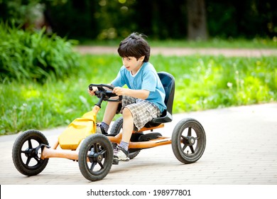 Boy Rides A Velomobile In The Park