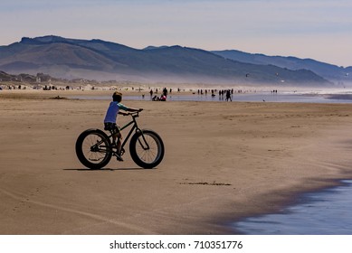Boy Riding Around On A Large Fat Tire Wheeled Bike On The Beach.