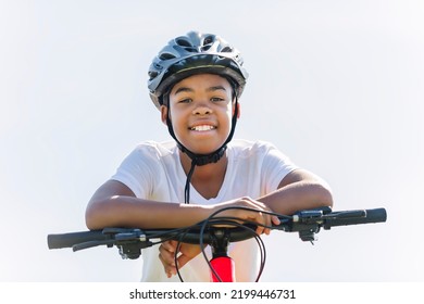 A boy riding bike wearing a helmet outside - Powered by Shutterstock