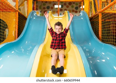 Boy riding from childrens slides on playground