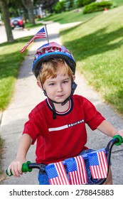 Boy Riding His Bicycle In A 4th Of July Neighborhood Parade.