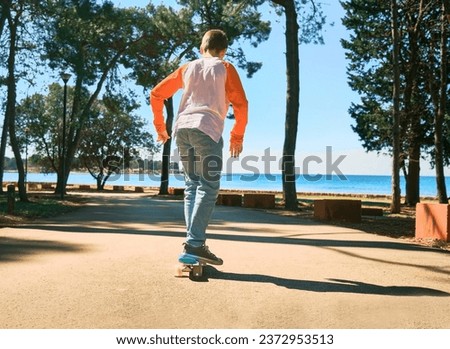 Boy riding skateboard outdoors in summer day in the road, Child learns to ride a penny board, Travel, sports concept.