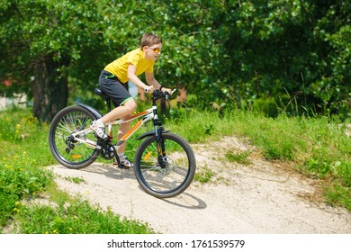 The Boy Is Rolling Downhill On A Bicycle