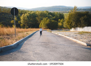 Boy Running Away On Road At Sunset