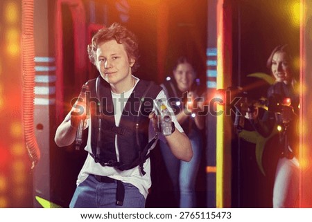 Boy running and dodging while playing lasertag