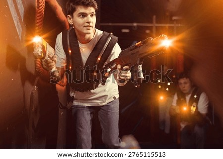 Boy running and dodging while playing lasertag