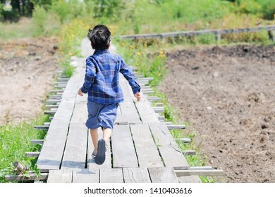 The boy is running forward.