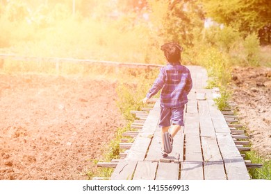 The boy is running forward.