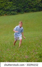 Boy Running In A Grassy Field Alone