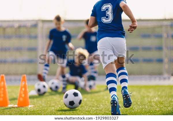 Boy Running on Grass Field in Soccer\
Cleats. Closeup image on Football Shoes.  Young Boy in Turf Boots\
for Playing Football on Natural and Artificial\
Ground