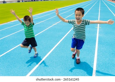 Boy Running On Racetrack In The Stadium