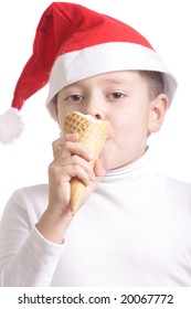 Boy in santa cap eats ice-cream over white background