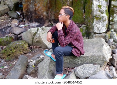 The Boy Sat On A Rock Looking Far Ahead. On September 22, 2021, Yogyakarta, Indonesia