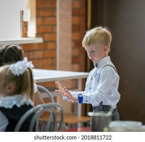 A Boy In A School Cafeteria Calms Schoolchildren With Outstretched Arms. First Graders Have Lunch On September 1st. Moscow, Russia, September 2, 2019